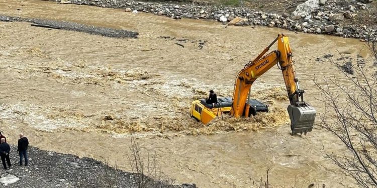 Sular yükselince iş makinesinin üzerinde mahsur kaldı